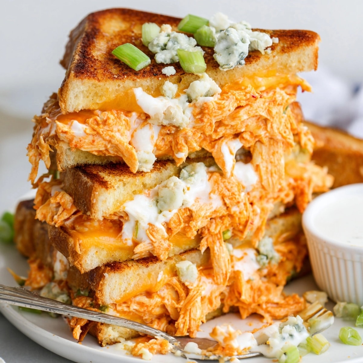Close-up reveals bubbling cheddar in a crispy Buffalo Chicken Grilled Cheese sandwich.