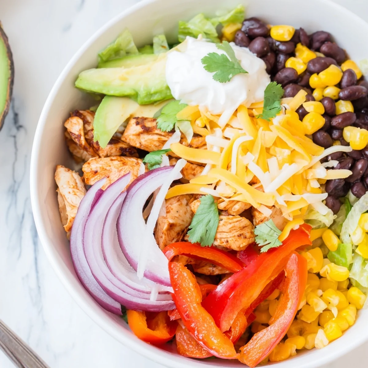 Colorful roasted vegetables and tender chicken in Sheet Pan Chicken Burrito Bowls.  