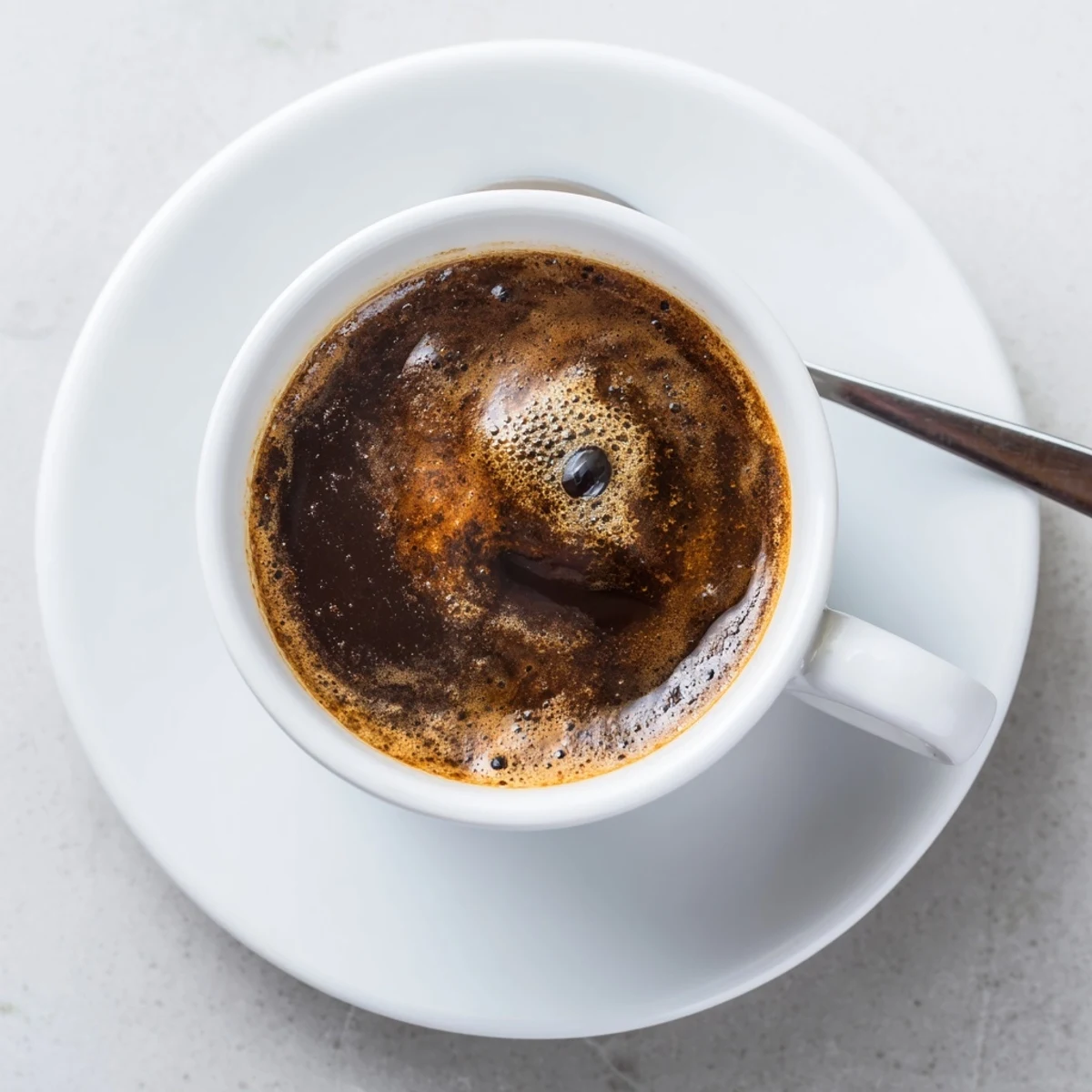 A steaming cup of brewed coffee with rich aroma and creamy foam.  