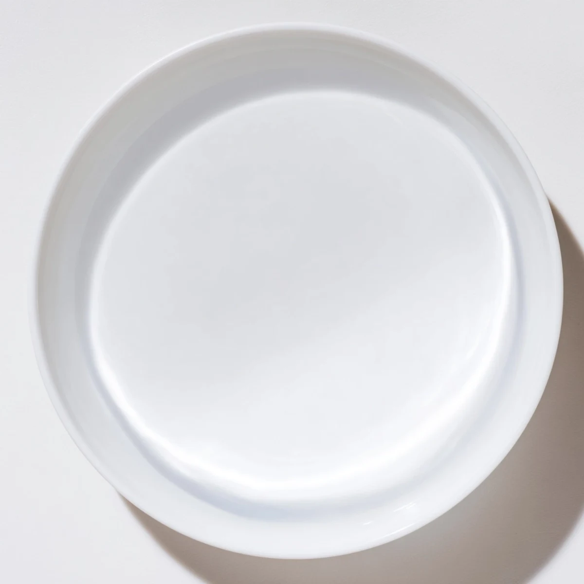 A clear glass of water sits beside a vibrant, colorful dinner plate.  