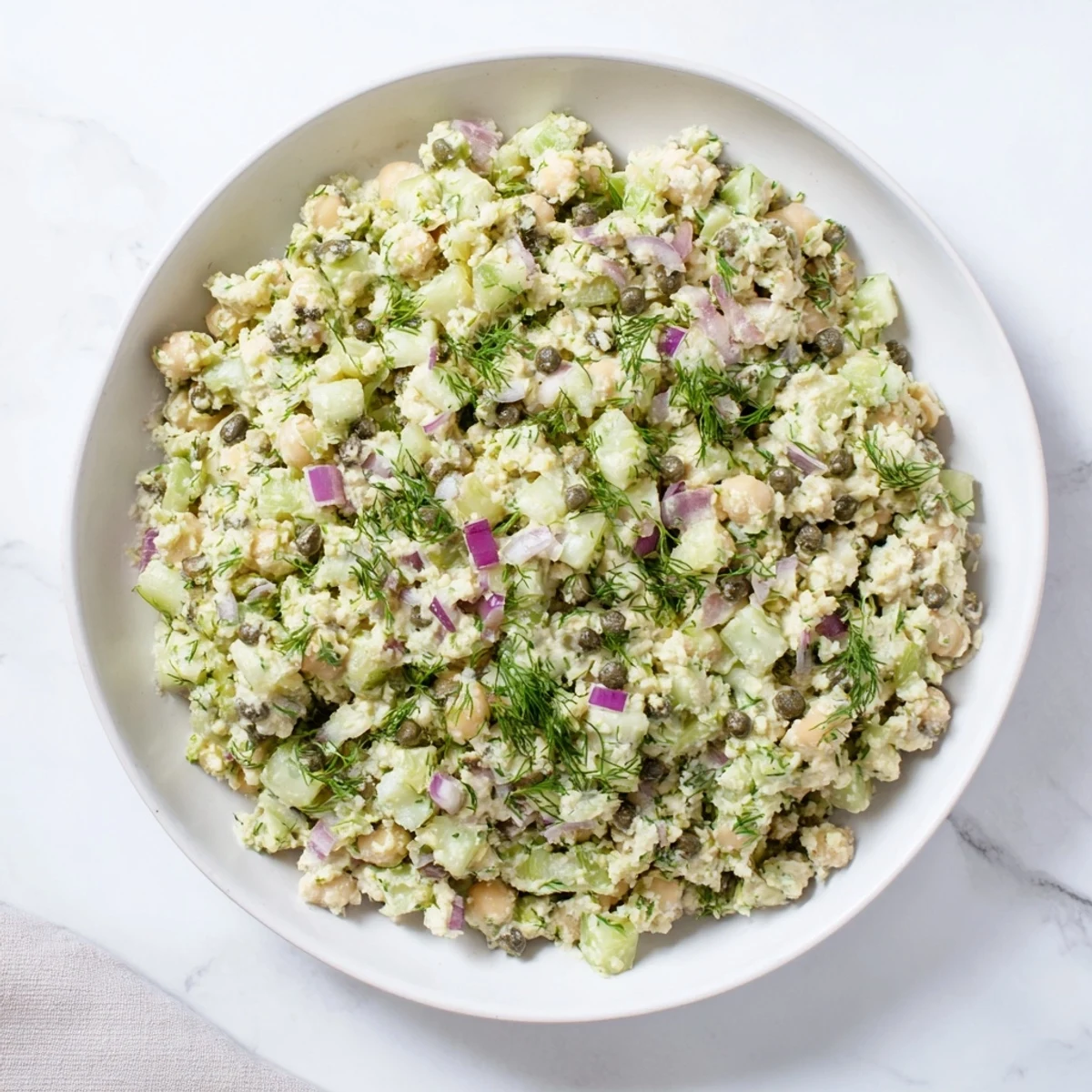 Freshly made chickpea tuna salad, with visible chunks of vegetables mixed into the creamy base.