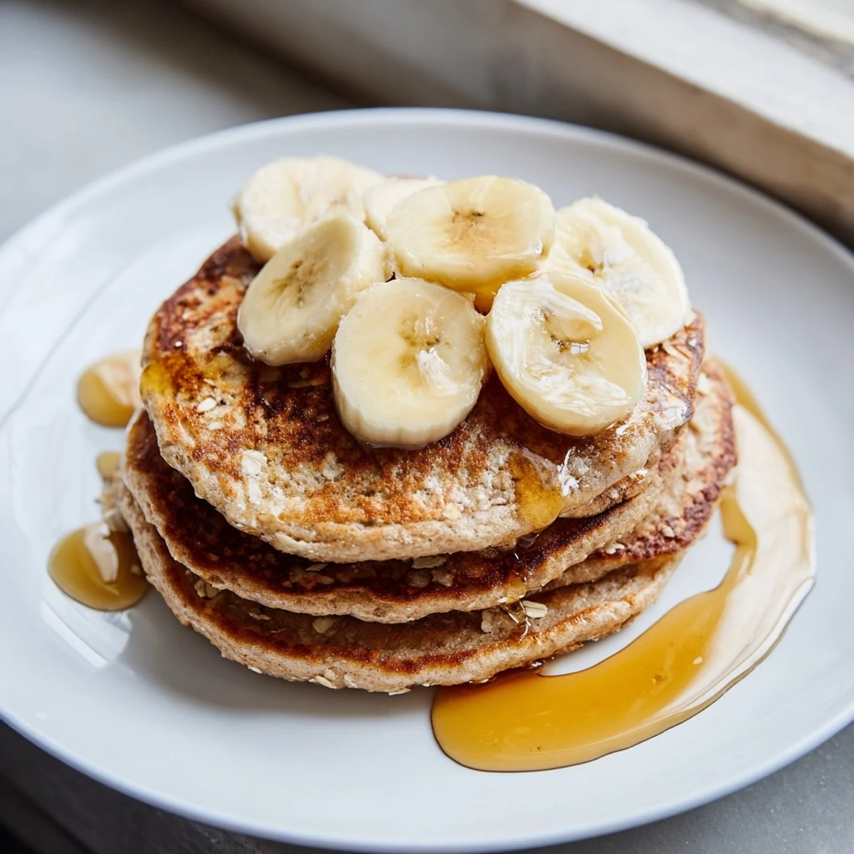 Delicious stack of banana oat pancakes, fluffy and smelling of cinnamon, perfect for breakfast.