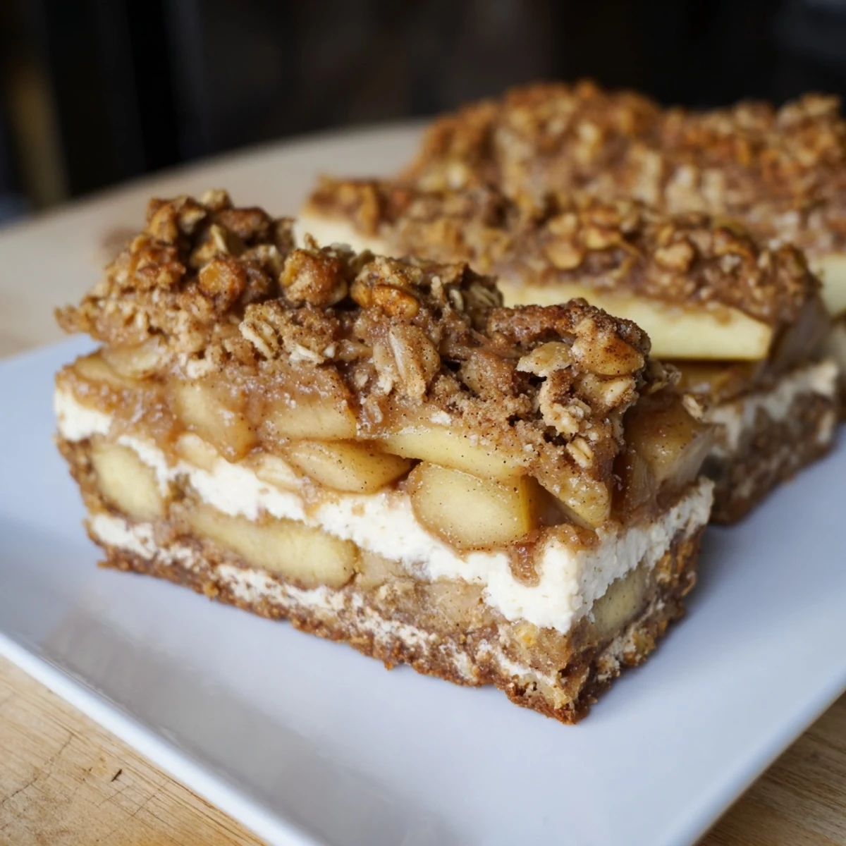 Golden-brown Apple Crisp Cheesecake Bars, a delicious dessert with a warm, spiced apple filling ready to enjoy.