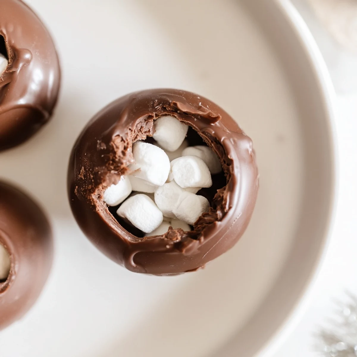 Delectable, melted chocolate surrounds a Budget-Friendly Hot Cocoa Bomb Cup, filled with fluffy marshmallows and cocoa mix.