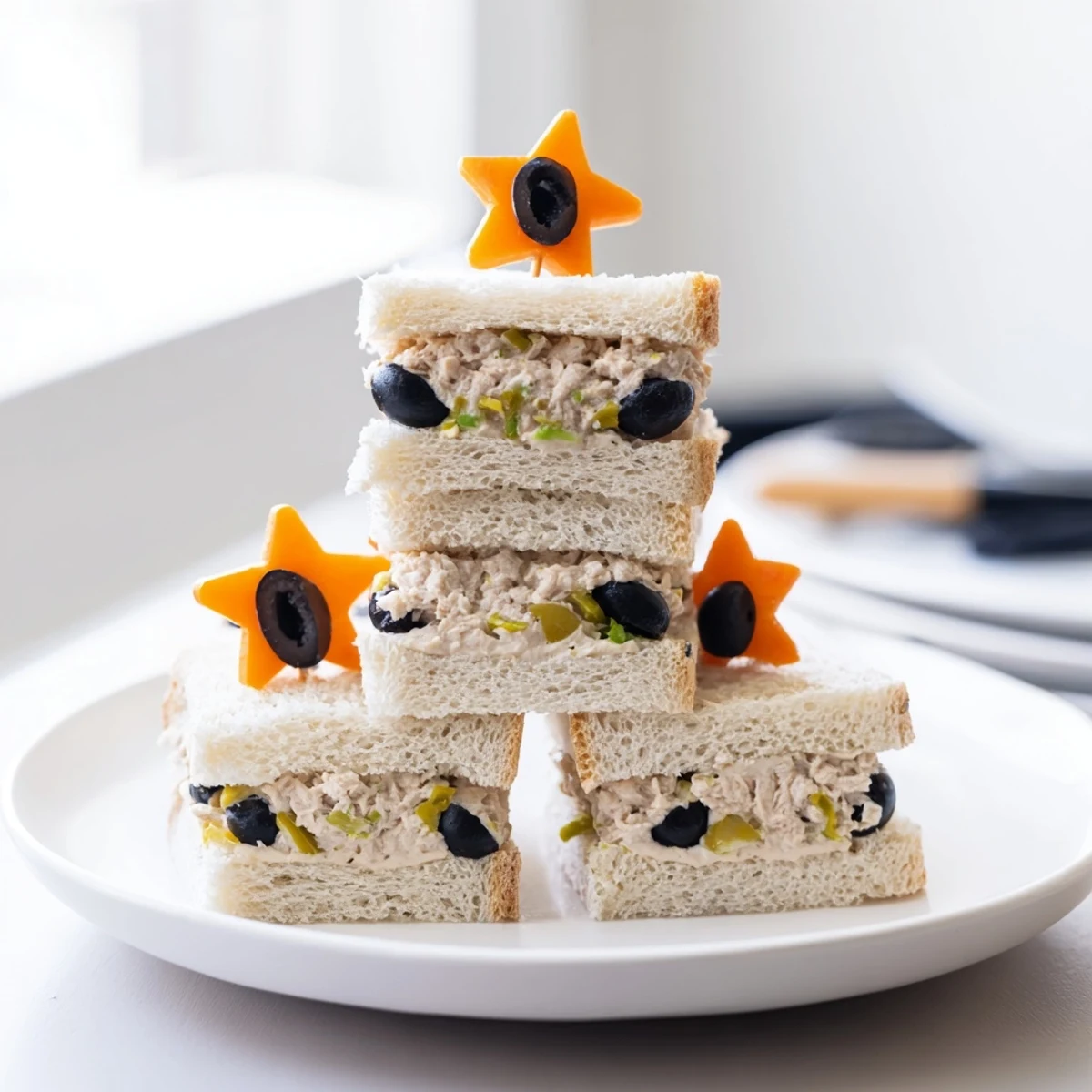 Golden mini starfish sandwiches filled with tuna, garnished with olive eyes, ready to serve.
