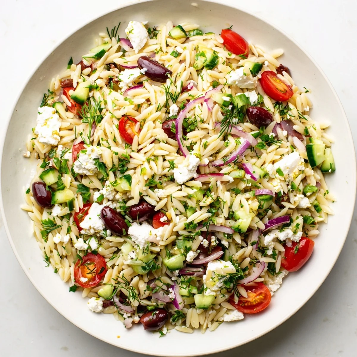 Delicious Greek orzo salad with a bright lemon dressing, perfect for a summer lunch.