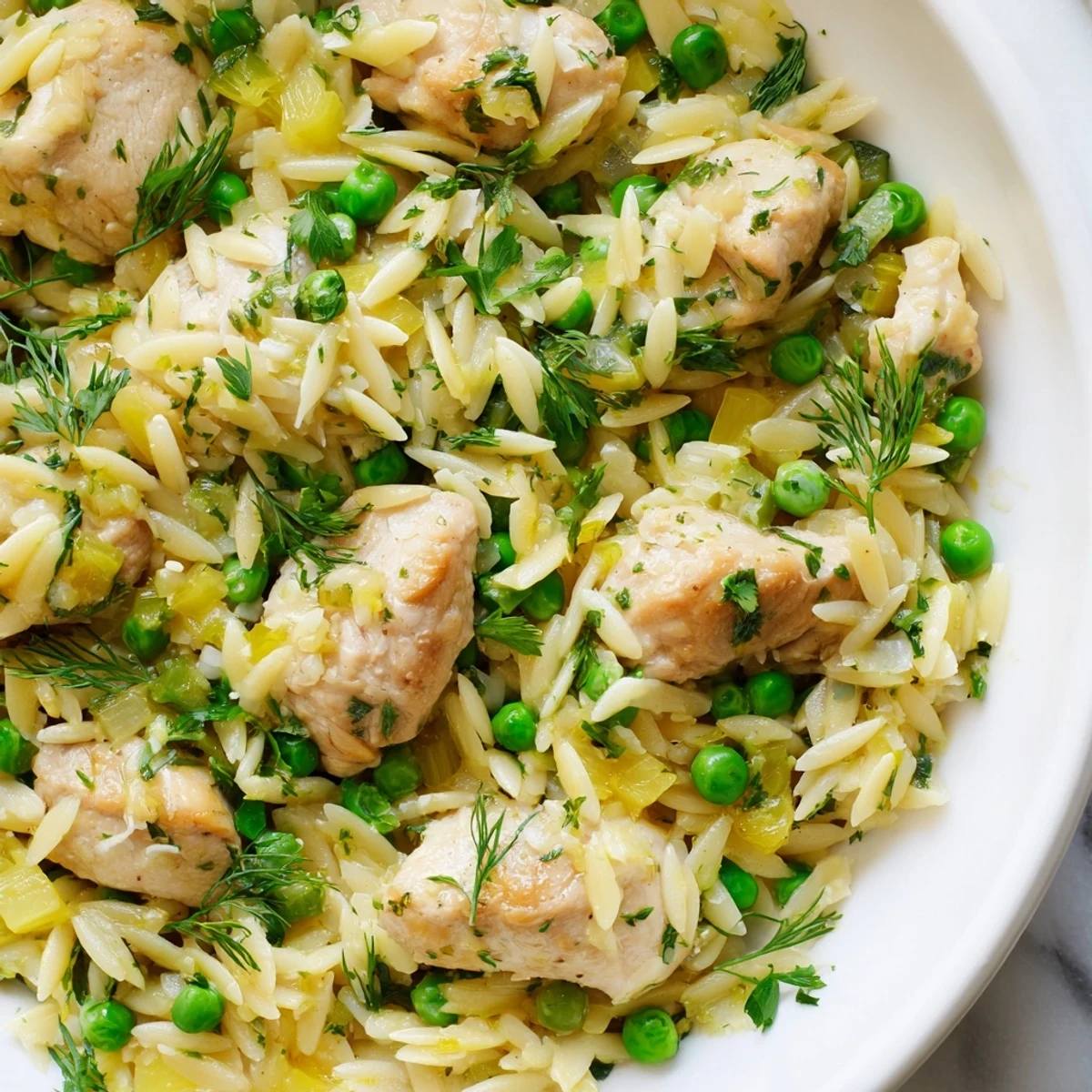 Tender chicken and orzo pasta, infused with lemon and herbs, a delicious skillet meal.