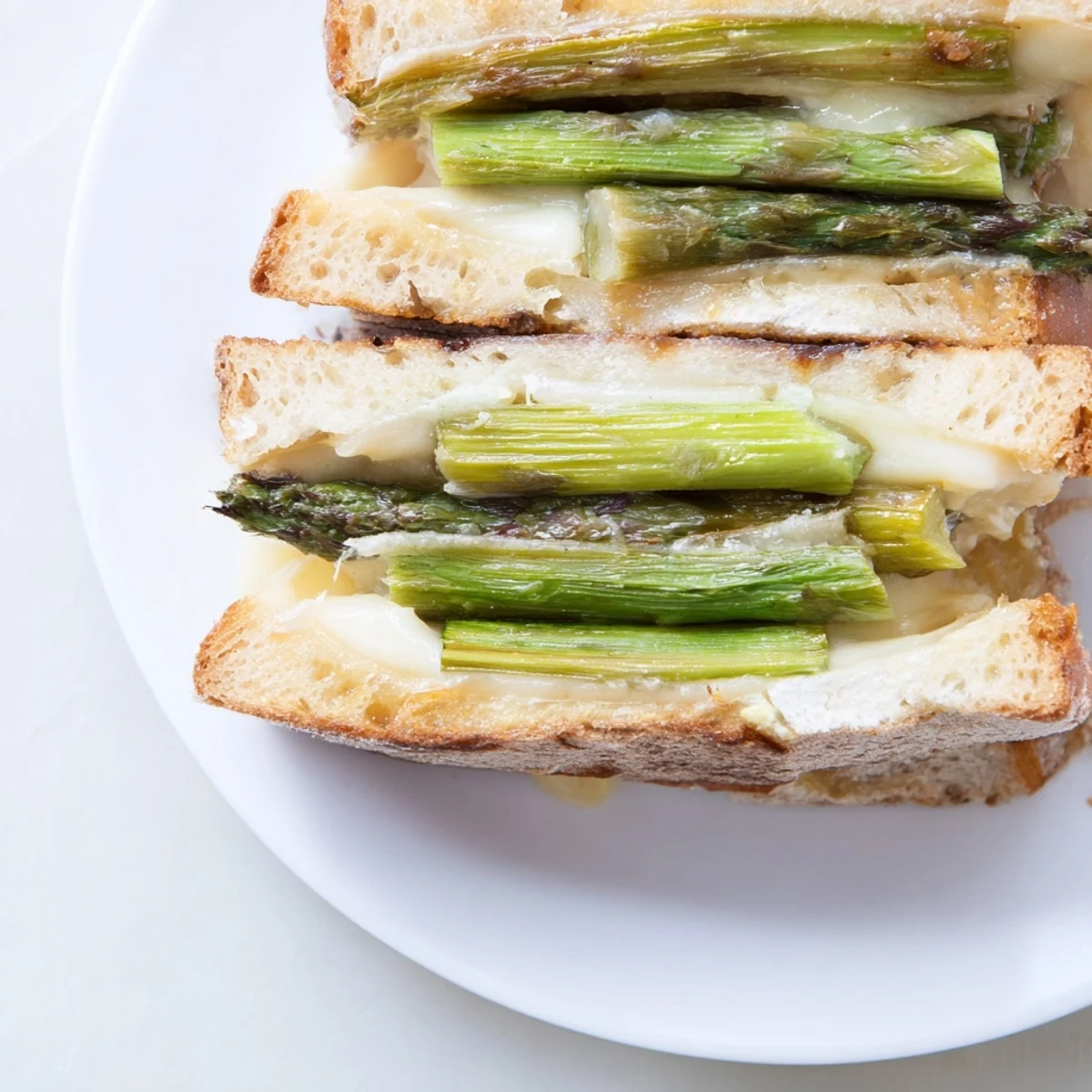 Close-up of a perfectly toasted Asparagus & Brie Grilled Cheese, ready to be sliced for a delicious meal.