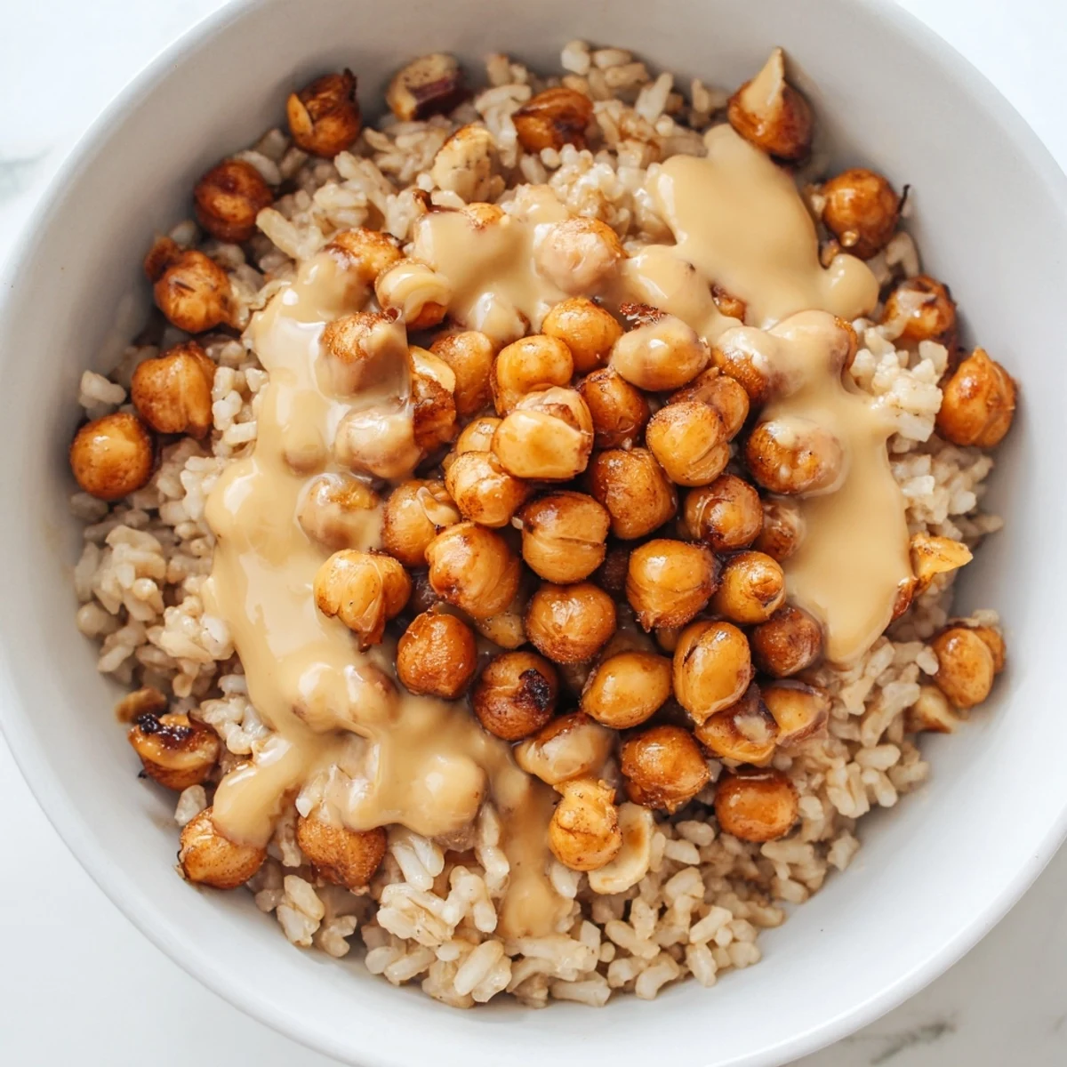 Heaping bowl of Peanut Chickpea Rice Bowl with tender chickpeas, crisp cucumber and cabbage, and a zesty peanut dressing, perfect for a quick and healthy weeknight dinner.
