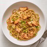 Delicious Japanese pan-fried salmon pasta served with lemon wedges for added zest.