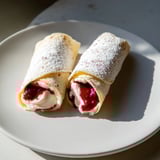 A close-up view of halved Snow Angel Tortilla Wraps reveals creamy cheese and berry jam filling.
