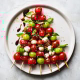 Delicious Caprese Skewer Tree with colorful tomatoes, mozzarella bites, and olive oil drizzle, perfect for a party.
