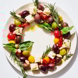 Appetizing Olive and Cherry Tomato Garland Board: a Mediterranean appetizer bursting with fresh flavors and color.