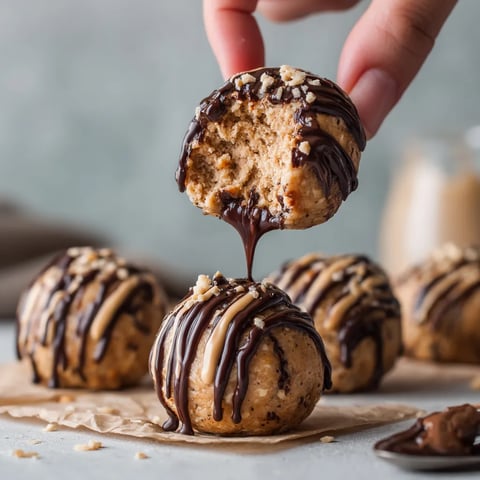 A hand is holding a chocolate covered doughnut.
