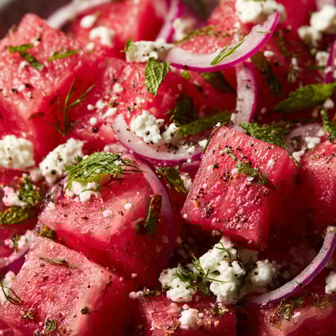 A salad made with watermelon, onions, and feta cheese.