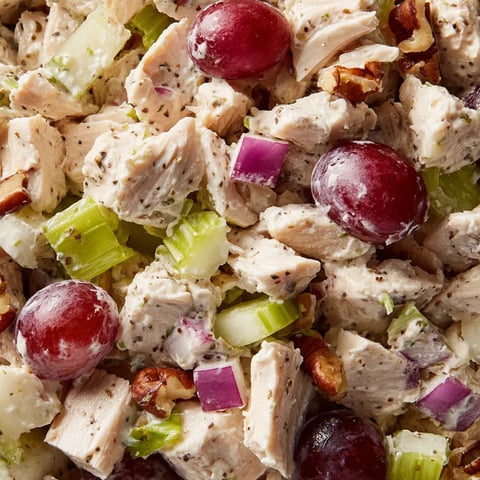 A close up of a chicken salad with grapes.