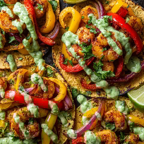 A close up of a delicious shrimp taco with a variety of toppings.