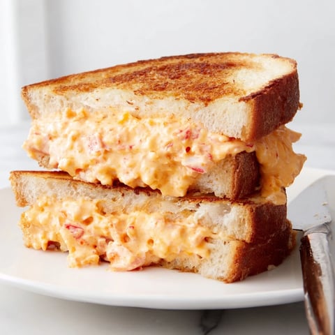 Decadent pimento cheese-stuffed grilled cheese sandwiches, golden brown and melty, waiting to be enjoyed.  