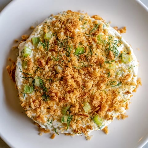 A bowl of creamy Fried Pickle Dip sprinkled with golden, crispy panko topping.