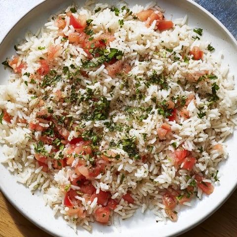 A vibrant Tomato-Rice Skillet Dinner, steaming hot, with fluffy rice and juicy tomatoes, ready to serve.