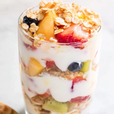 Vibrant yogurt parfait with colorful fruit and crunchy granola, a quick breakfast idea.