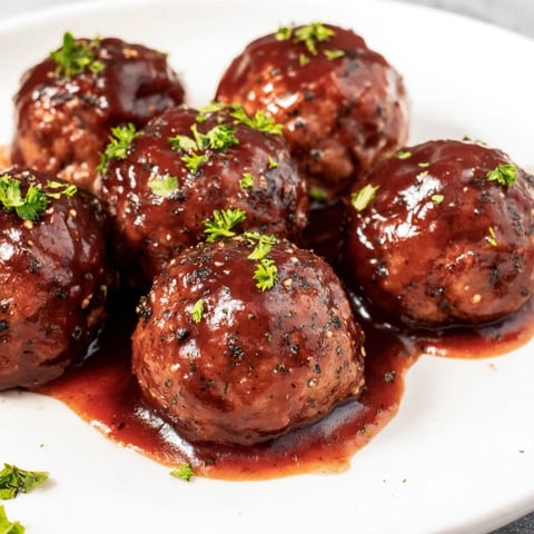 Slow cooker cherry BBQ meatballs glistening in a sweet, tangy sauce, perfect for a party.