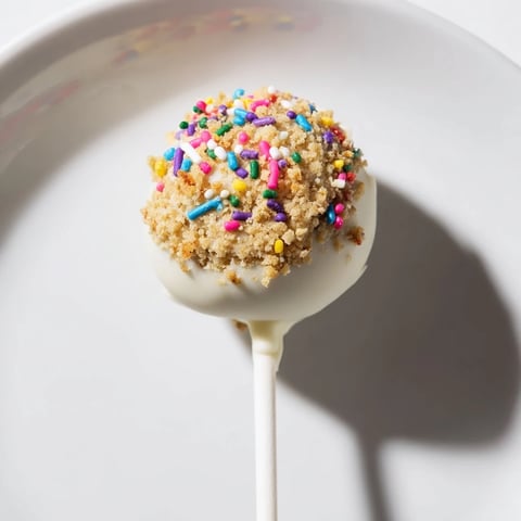 Close-up of Lightened-Up Sugar Cookie Cake Pops, dipped in white chocolate and covered in colorful sprinkles.