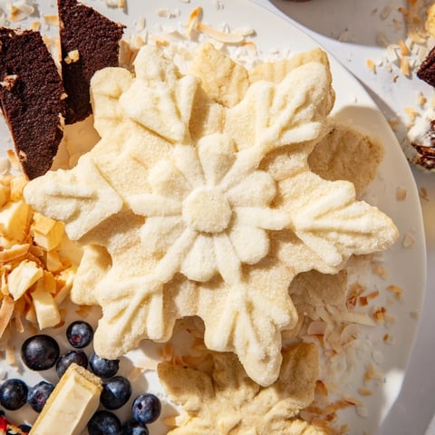 A stunning Snowflake Dessert Board with varied textures and vibrant berry colors arranged as a centerpiece.