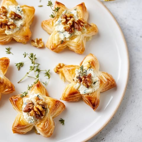 Golden puff pastry stars with goat cheese and honey atop flavorful Starry Night New Years Appetizers.
