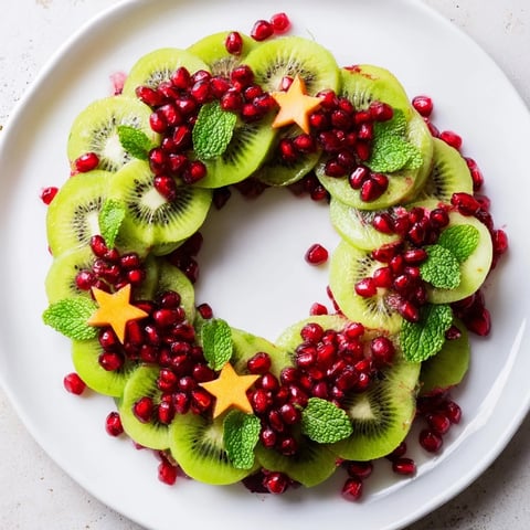 Vibrant Kiwi and Pomegranate Christmas Wreath showcases ripe kiwi and ruby pomegranate seeds for a healthy treat.