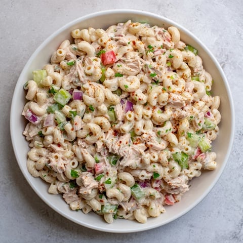 A creamy, chilled Chicken Macaroni Holiday Salad, filled with colorful veggies and a tangy dressing.