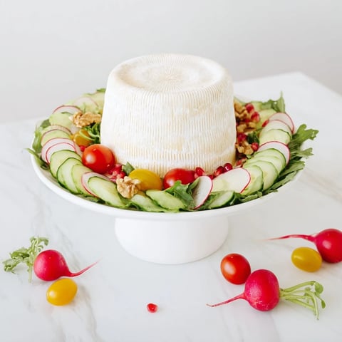 The Zenith Point salad featuring a creamy artisanal cheese wheel, beautifully arranged and ready to serve.