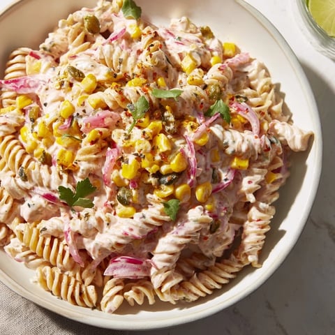 Creamy Street Corn Pasta Salad with charred corn kernels and a vibrant cilantro garnish.
