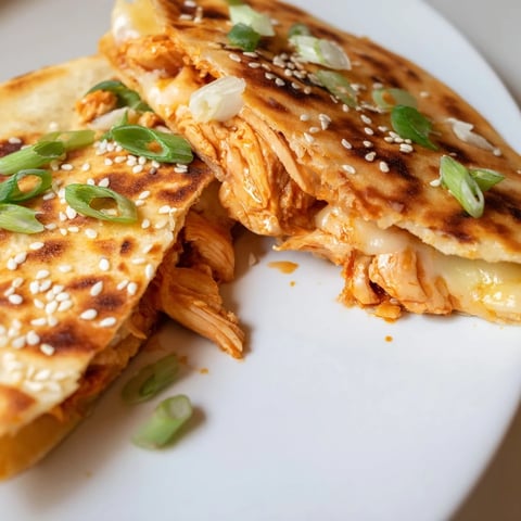 Golden-brown Korean BBQ Chicken Wrap Grilled Cheese, oozing with melted cheese and fresh green scallions.