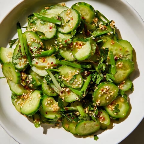 Zesty Shake Cucumber Salad with glistening cucumbers tossed in a tangy soy-sesame dressing, ready to eat.