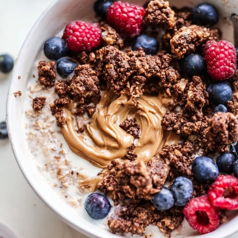 Creamy overnight oats gourmet makeover with swirls of nut butter, berries, and cookie crumbles.