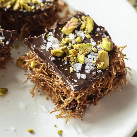 Golden, crispy kataifi and dark chocolate crunch bark with chopped pistachios, ready to break.