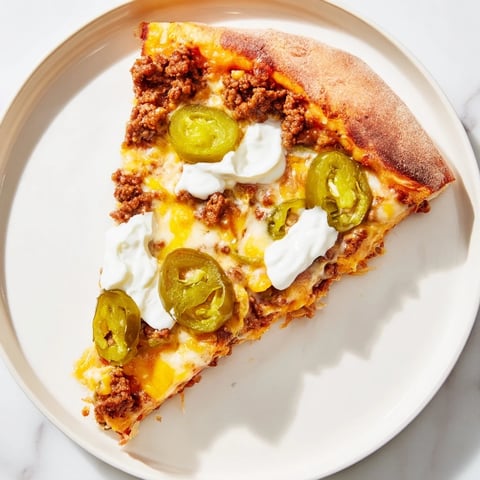 Ground beef taco pizza with melty cheese and jalapeños, ready to slice and enjoy.