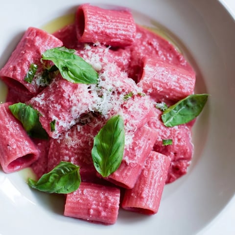 Vibrant pink pasta with beet cream simmering in a pan, ready for a delicious Italian-inspired dinner.