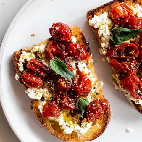 Golden Baked Feta Toast with bubbly cheese, sweet tomatoes, and fresh basil, ready to eat.