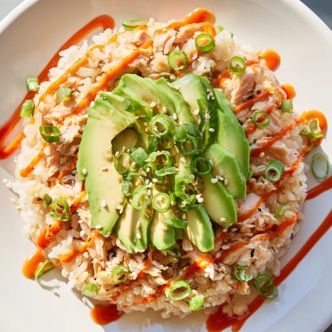 Flaked salmon atop fluffy rice, a complete Emily Mariko Salmon Rice Bowl, ready to be enjoyed.