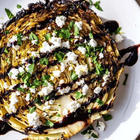 Crispy Cabbage Steaks with Feta and Balsamic glisten with balsamic glaze on a rustic wooden board.  