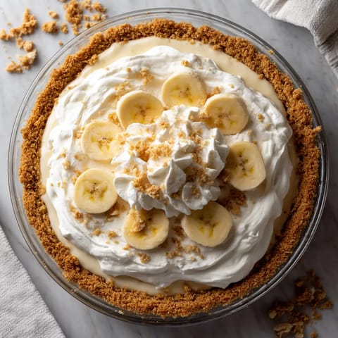 A pie with bananas and whipped cream.