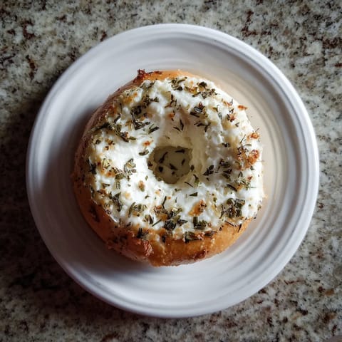 A white plate with a bagel on it.