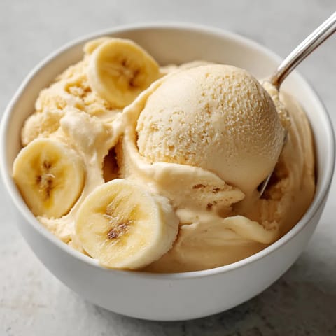 A bowl of ice cream with bananas.