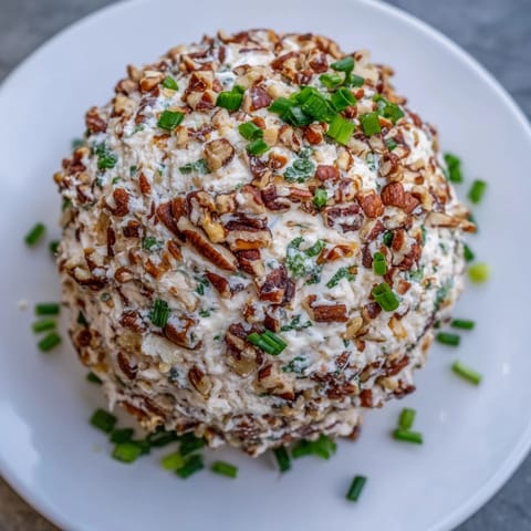 The creamy ranch-flavored Classic Cheese Ball, a party appetizer, rolled in chopped nuts.