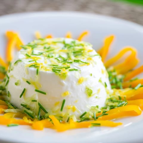 This Tuscan Sunburst recipe features creamy goat cheese surrounded by bright yellow pepper "sunbeams" for enjoyment.