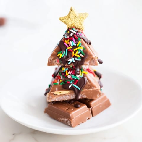 Homemade Chocolate Kinder Christmas Trees: stacked with chocolate and adorned with festive stars, ready for a dessert.