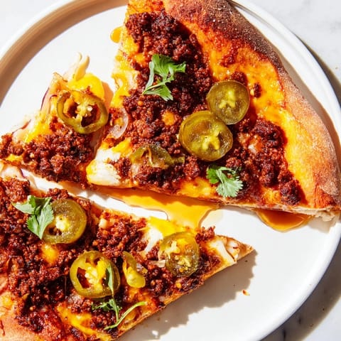 Golden baked spicy ground beef pizza base, featuring melted mozzarella and cheddar, ready to eat.