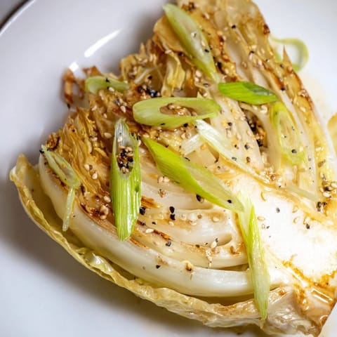 Freshly roasted Miso Butter Roasted Cabbage Wedges sprinkled with sesame seeds and sliced green onions.